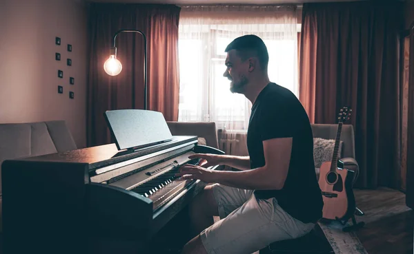 Bir Erkek Müzisyen Ampulü Yanan Bir Odada Elektronik Piyano Çalar — Stok fotoğraf