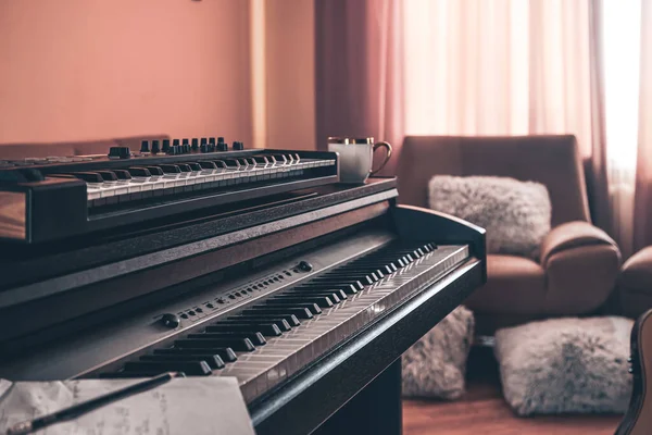 Electronic piano in the interior of the room on a blurred background.