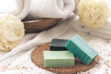 Renkli el yapımı sabunlu spa kompozisyonu havlularla bulanık arkaplan üzerinde yakın plan.
