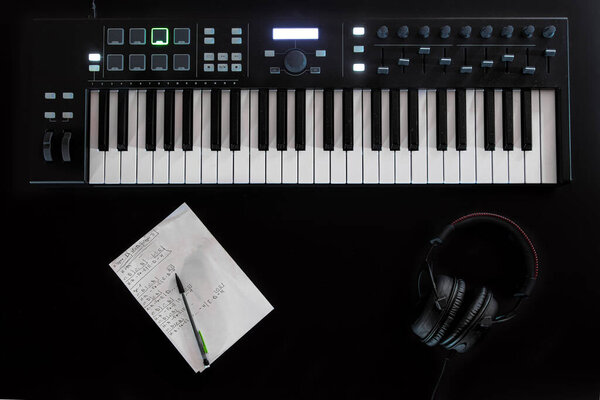 Musical background with musical keys on black, flat lay, copy space.