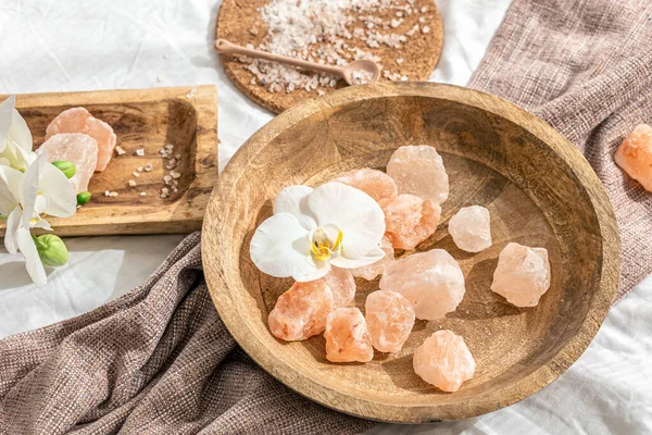 Tahta bir tabakta deniz tuzu parçalarıyla spa kompozisyonu.