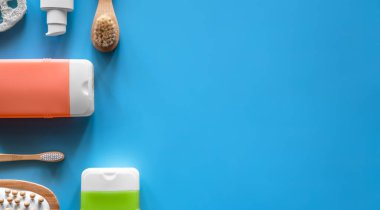 Mavi arka planda duş ve kişisel bakım ürünleri içeren spa kompozisyonu.