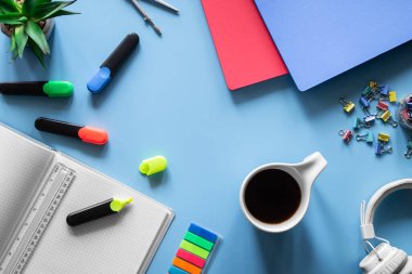 Kırtasiye ürünleri, öğrenci ve öğrenci işyeri konsepti ile mavi arka planda düz uzandı.