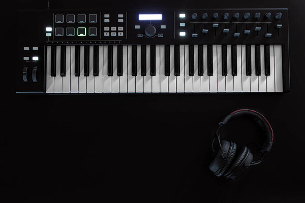 Musical background with musical keys on black, flat lay, copy space.