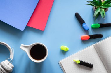 Kırtasiye ürünleri, öğrenci ve öğrenci işyeri konsepti ile mavi arka planda düz uzandı.