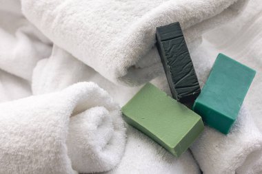 Renkli el yapımı sabunlu spa kompozisyonu havlularla bulanık arkaplan, üst görünüm.