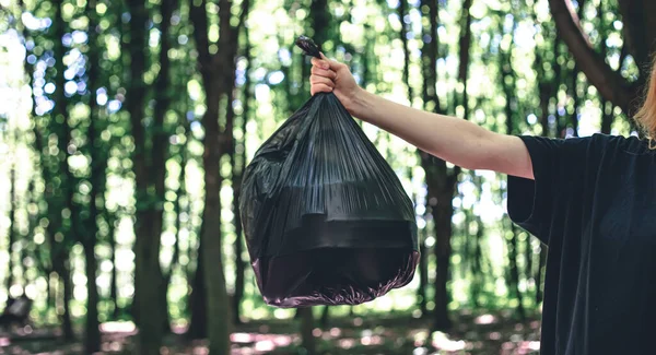 Close Sekantong Sampah Dengan Latar Belakang Hutan Yang Kabur Konsep — Stok Foto