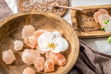 Tahta bir tabakta deniz tuzu parçalarıyla spa kompozisyonu.