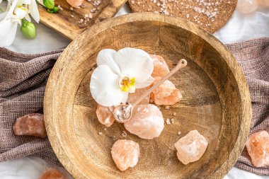 Tahta bir tabakta deniz tuzu parçalarıyla spa kompozisyonu.