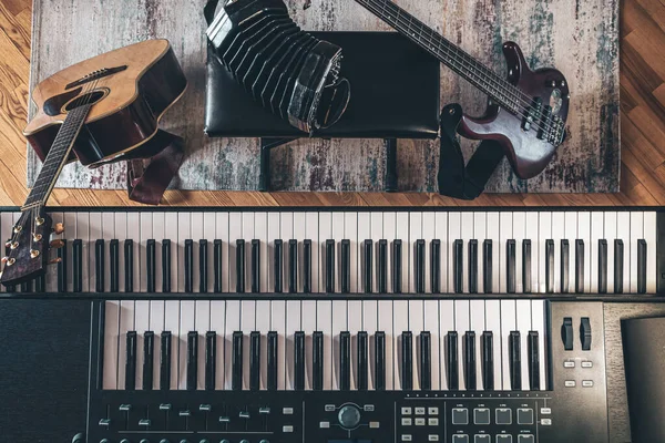 Piano keys, acoustic guitar and other instruments, top view, musicians workplace.