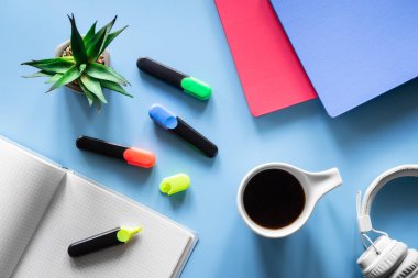 Kırtasiye ürünleri, öğrenci ve öğrenci işyeri konsepti ile mavi arka planda düz uzandı.