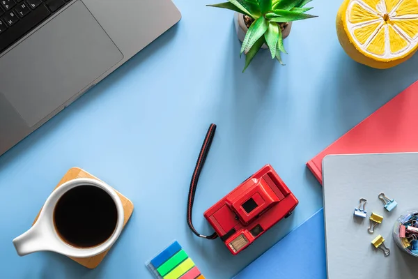 Students workplace, creative composition with stationery items on a blue background.