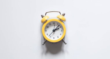 Beyaz zemin üzerindeki sarı alarm saati izole, düz konum, zaman kavramı, kavramsal minimalizm.