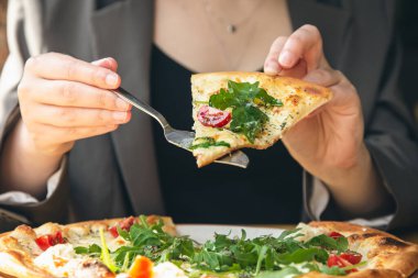 Yakın plan, sebzeli vejetaryen pizza, yanında vişneli domates ve roka..