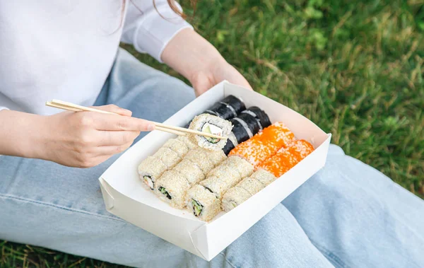 Close Woman Eating Sushi Box Picnic Sushi Delivery Concept — стоковое фото