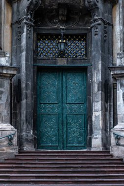 Ancient doors in the cathedral, turquoise old doors, classical architecture, detail.