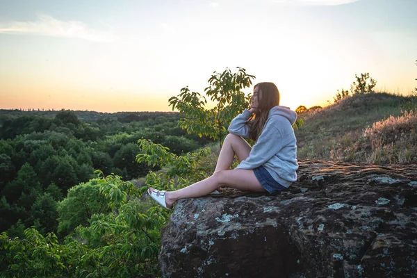 Eine Junge Frau Sitzt Auf Einem Stein Vor Der Kulisse — Stockfoto