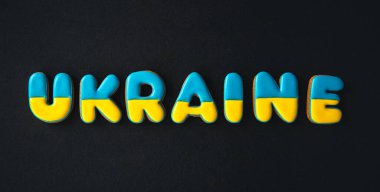 Siyah arka planda Ukrayna kelimesi, el yapımı zencefilli çörekten yapılmış, savaş konsepti yok, düz yatıyordu..