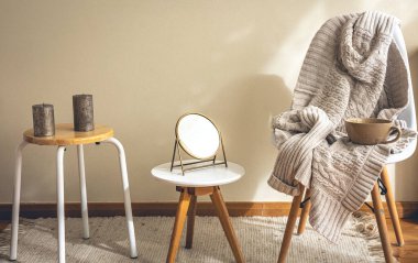 Minimalist bir evin iç dekorasyonu, dekorasyon detayları, bir ayna, mumlar ve örgü bir element..