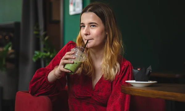 Молодая Женщина Красном Платье Кафе Пьет Летний Зеленый Напиток Латте — стоковое фото