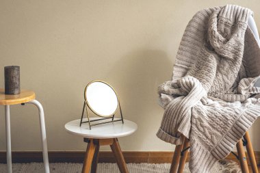 Minimalist bir evin iç dekorasyonu, dekorasyon detayları, bir ayna, mumlar ve örgü bir element..