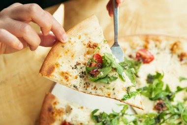 Yakın plan, sebzeli vejetaryen pizza, kiraz domatesleri ve ahşap bir masada roka..