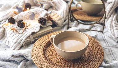 Sıcak bir sonbahar kompozisyonu, büyük bir fincan kahve ve şirin dekorasyon detaylarıyla..