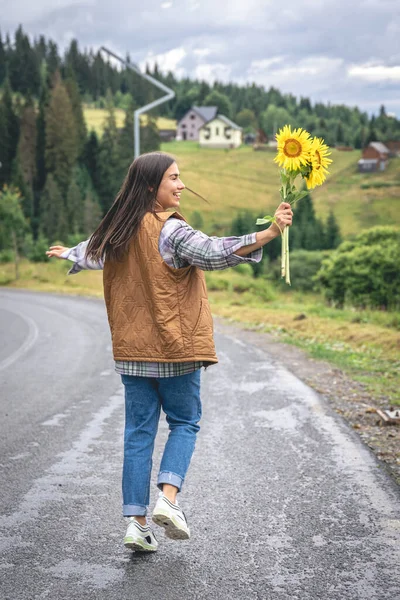 Young Woman Bouquet Sunflowers Walks Paved Road Mountains — Stock fotografie
