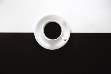 Cup of coffee on a black and white background, flat lay, conceptual minimalism.