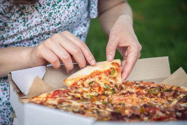 Piece of pizza close-up, concept of picnic and relaxation.