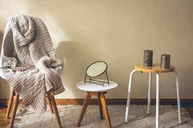 Minimalist bir evin iç dekorasyonu, dekorasyon detayları, bir ayna, mumlar ve örgü bir element..