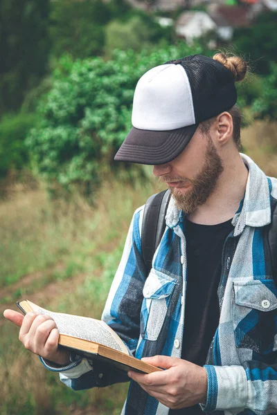 Man Plaid Shirt Cap Reads Book Nature — Stok fotoğraf
