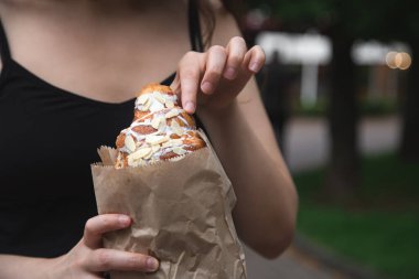 Croissant in a craft paper bag in female hands, pastries to go.