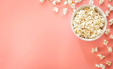 Popcorn on pink background, flat lay, concept of watching movies and series.
