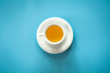 Cup of tea on a blue background isolated, flat lay, conceptual minimalism.