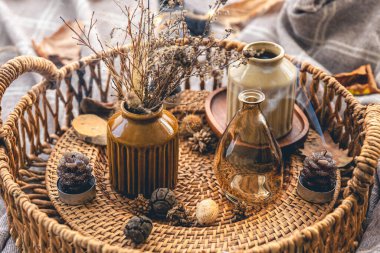 Cozy autumn composition with decorative details, candles on the background of a plaid.