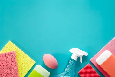 Mavi zemin üzerinde ev temizleme ürünleri, düz uzanma, kopyalama alanı.