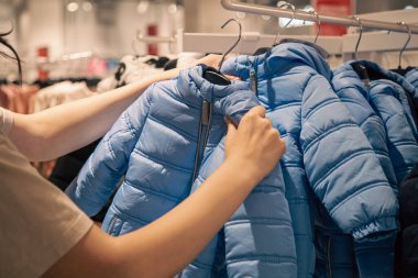 Warm childrens jackets on hangers in a clothing store., the concept of shopping for clothes for children.