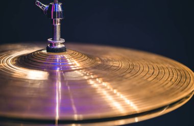 Hi-hat close-up of plates with drumsticks on a background of colored lanterns. Musical concept with a working drum.