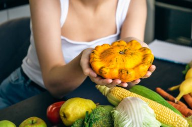 Mutfakta sebzelerin arasında bir kadının ellerinde ezilmek, yemek pişirme ve sağlıklı beslenme kavramı..