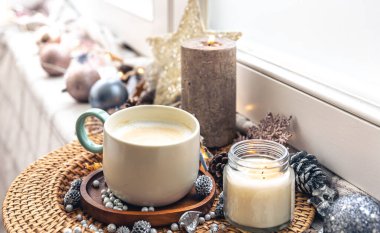 Cozy winter composition with a cup of coffee and festive decor details.