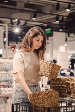 Dekor mağazasında el yapımı hasır işi seçen bir kadın tasarımcı.