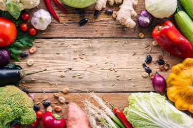 Ahşap arka plandaki sebze çerçevesi, düz konum, hasat konsepti, düzgün beslenme, malzemeler ve Şükran Günü..