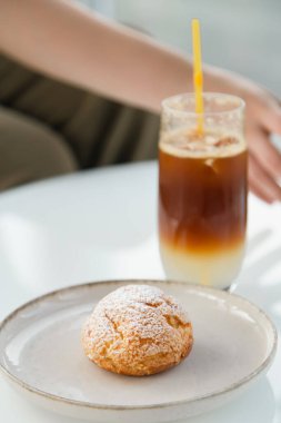 Coffee cooling drink espresso tonic in a glass and shu cake with cream inside.
