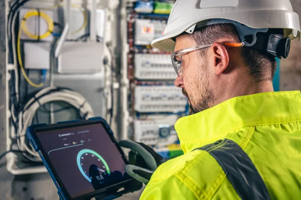 Man, an electrical technician working in a switchboard with fuses. Installation and connection of electrical equipment.