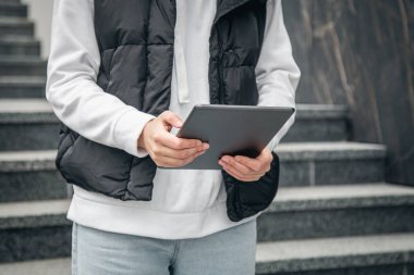 Kapatın, kadın tablet kullanıyor, şehir arka planı bulanık, vücut parçası.