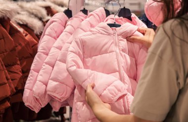 Warm childrens jackets on hangers in a clothing store., the concept of shopping for clothes for children.
