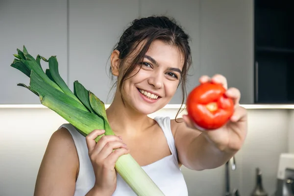 Jovencita Alegre Cocina Sosteniendo Puerro Tomate Sus Manos Concepto Alimentación — Foto de Stock