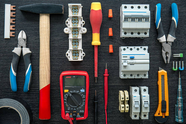 Flat lay composition with electrical tools on wooden background.