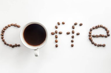 Kahveyi beyaz arka planda kahve yapan bir fincan kahve ve kahve çekirdeğinin yaratıcı düzlüğü..